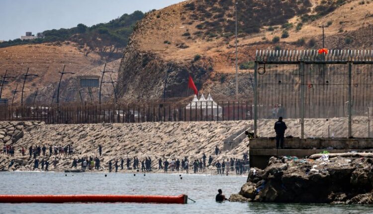 Spanish security personnel patrol the breakwater at the Ceuta border as authorities begin installing a sea barrier following a large migrant crossing from Morocco.